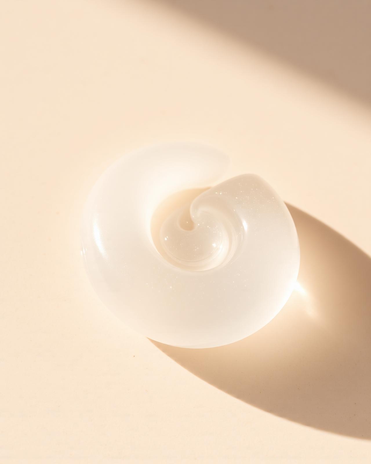 Close-up of a translucent skincare gel texture on cream stone